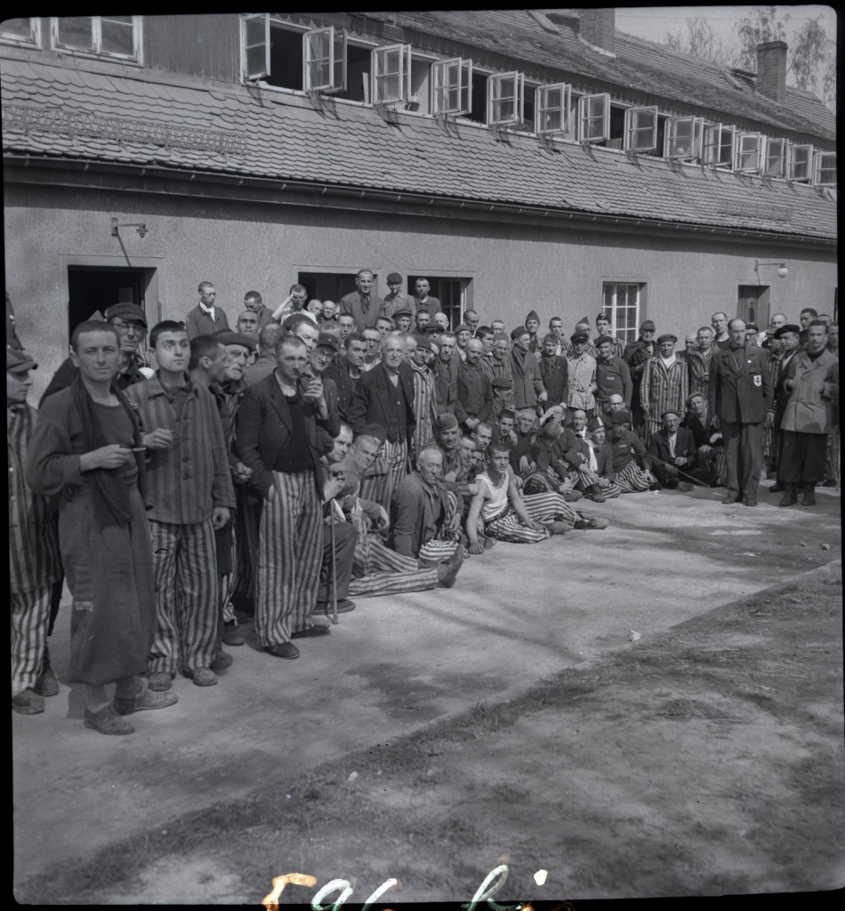 Französische Überlebende haben sich anlässlich eines Besuchs des In-ternationalen Roten Kreuzes vor dem früheren SS-Revier zum Gruppenfoto aufgestellt, 17./​18. April 1945, Comité International de la Croix-Rouge, Genève