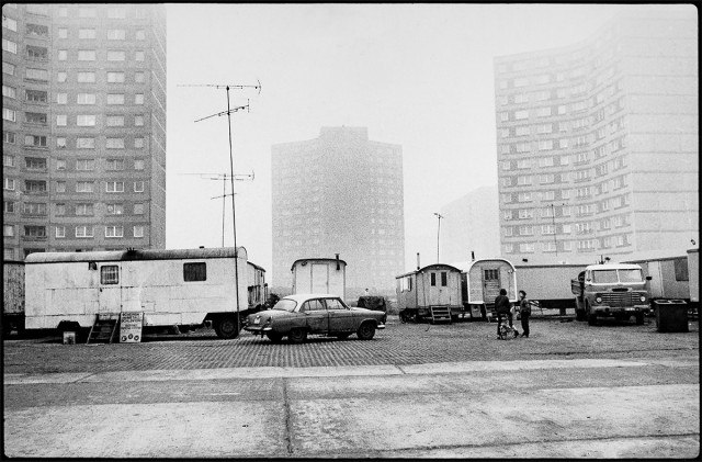 Wohnwagen vor Plattenbauten. Die meisten Sinti sind sesshaft, doch werden sie bis heute als "fahrendes Volk" stigmatisiert, © Markus Hawlik-Abramowitz, aus dem Fotoband »Sinti in der DDR. Alltag einer Minderheit«